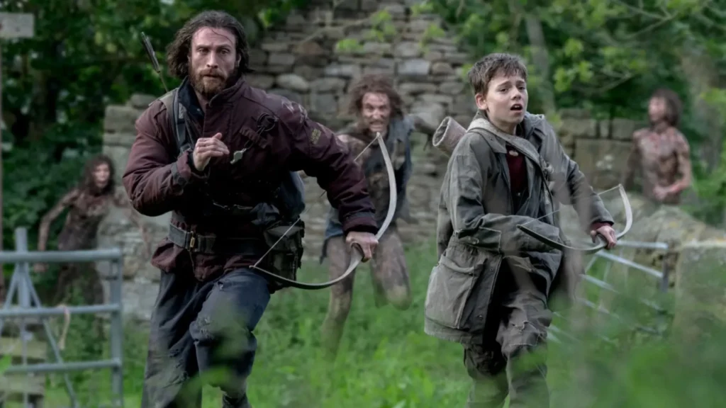 Aaron Taylor-Johnson and Alfie Williams as Jamie and Spike running with bows, pursued by an infected person in '28 Years Later'.