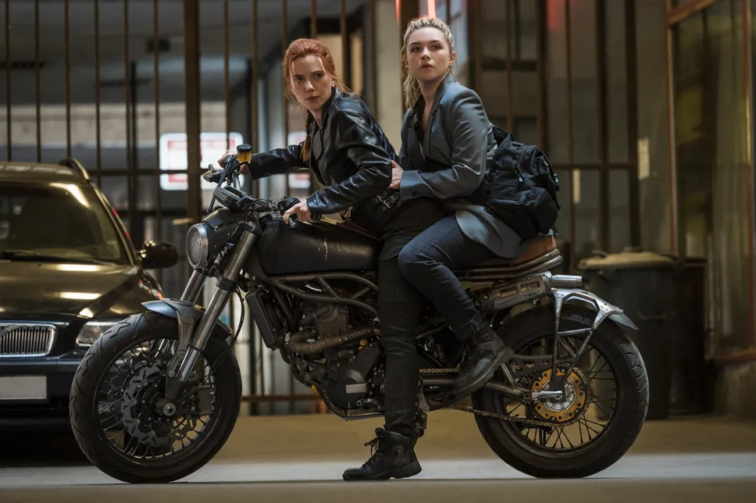 Natasha Romanoff and Yelena Belova riding a motorcycle together during an action sequence in Marvel’s Black Widow.